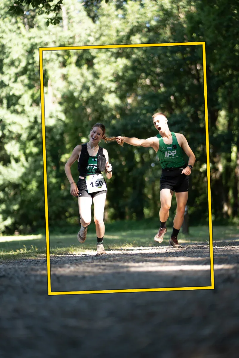 Two runners, bib 150 — plein cadre brut, penché avant redressement