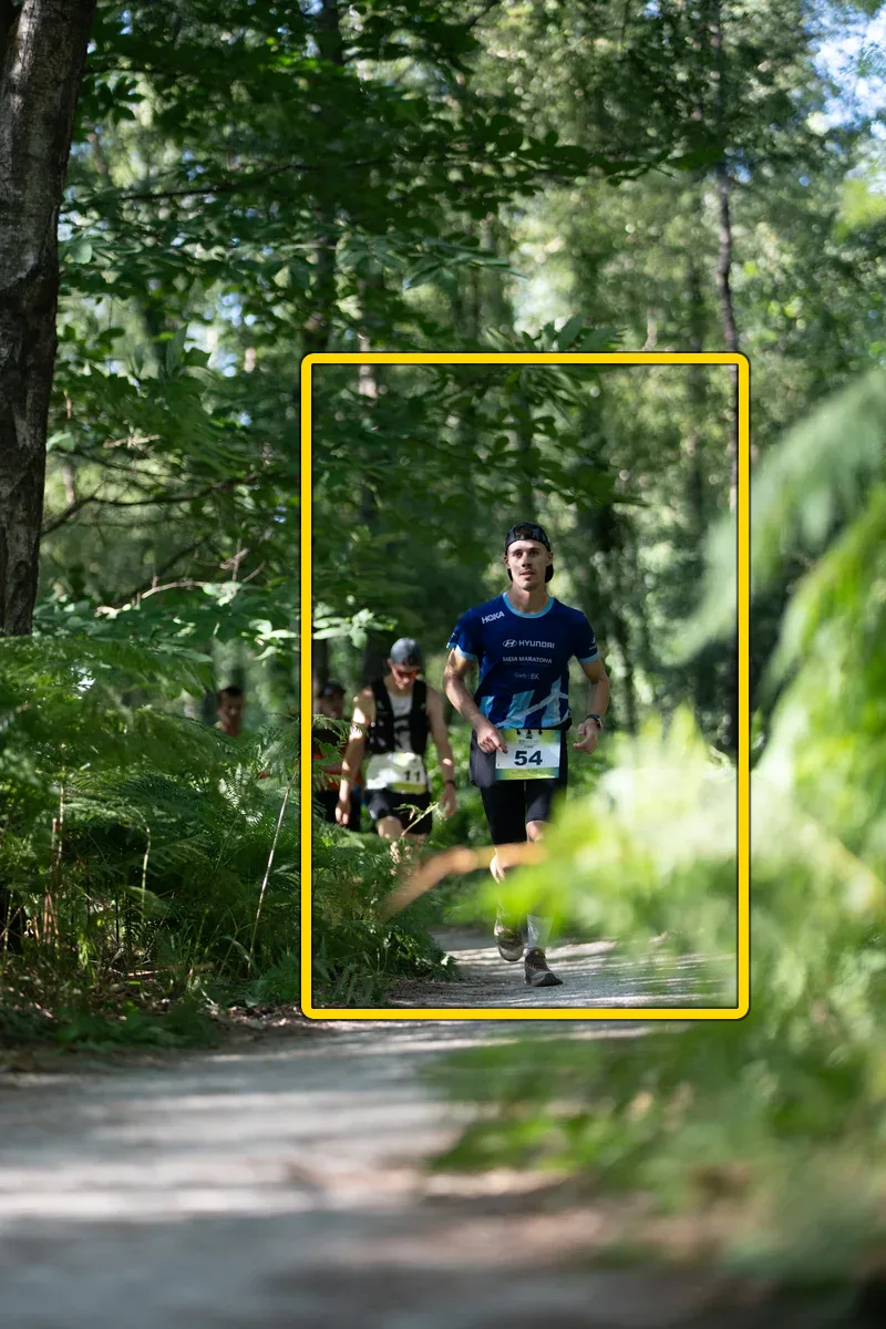 Runner with bib 54 — plein cadre brut, penché avant redressement